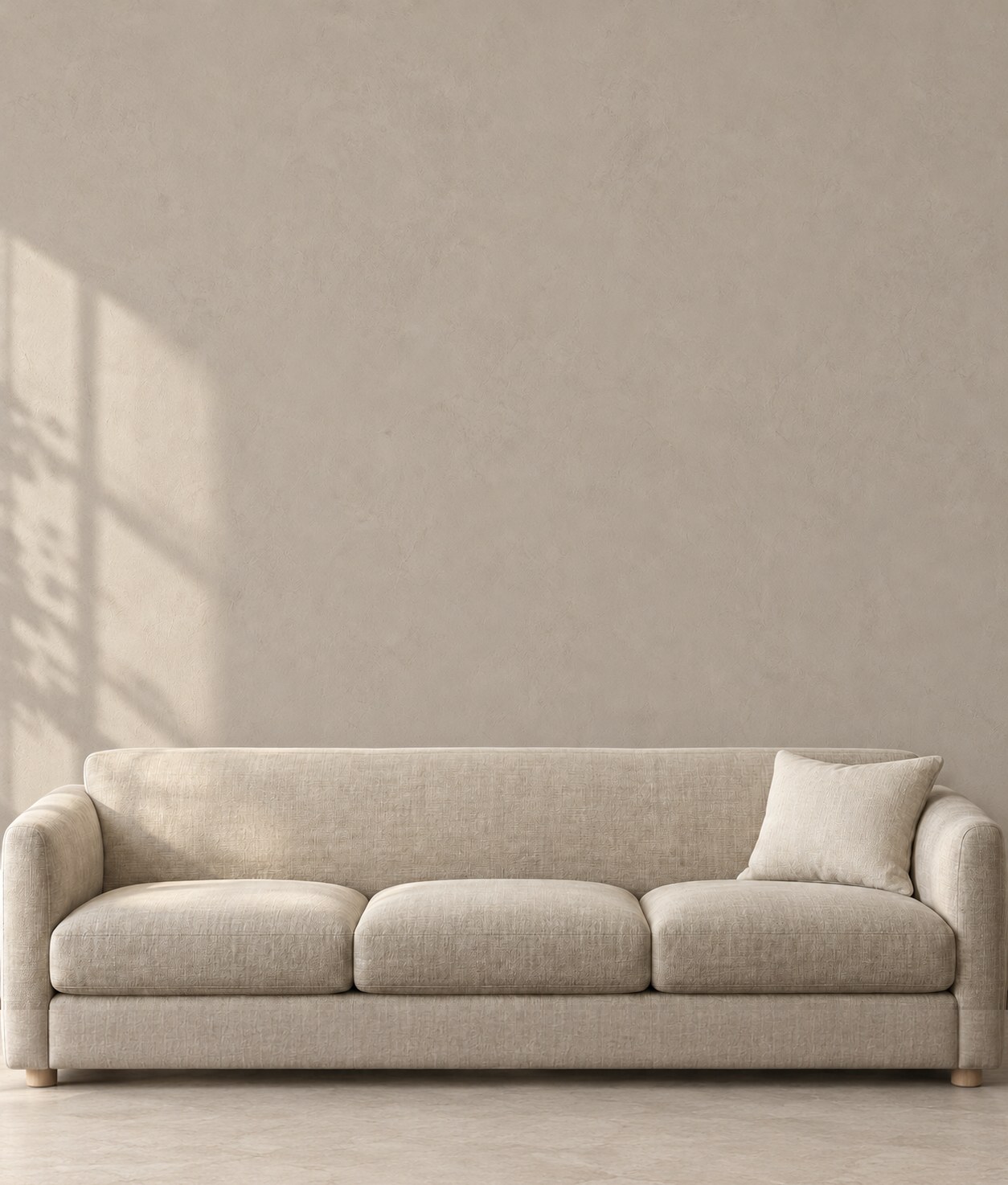 An ivory wall with an 87 in (220 cm) linen sofa