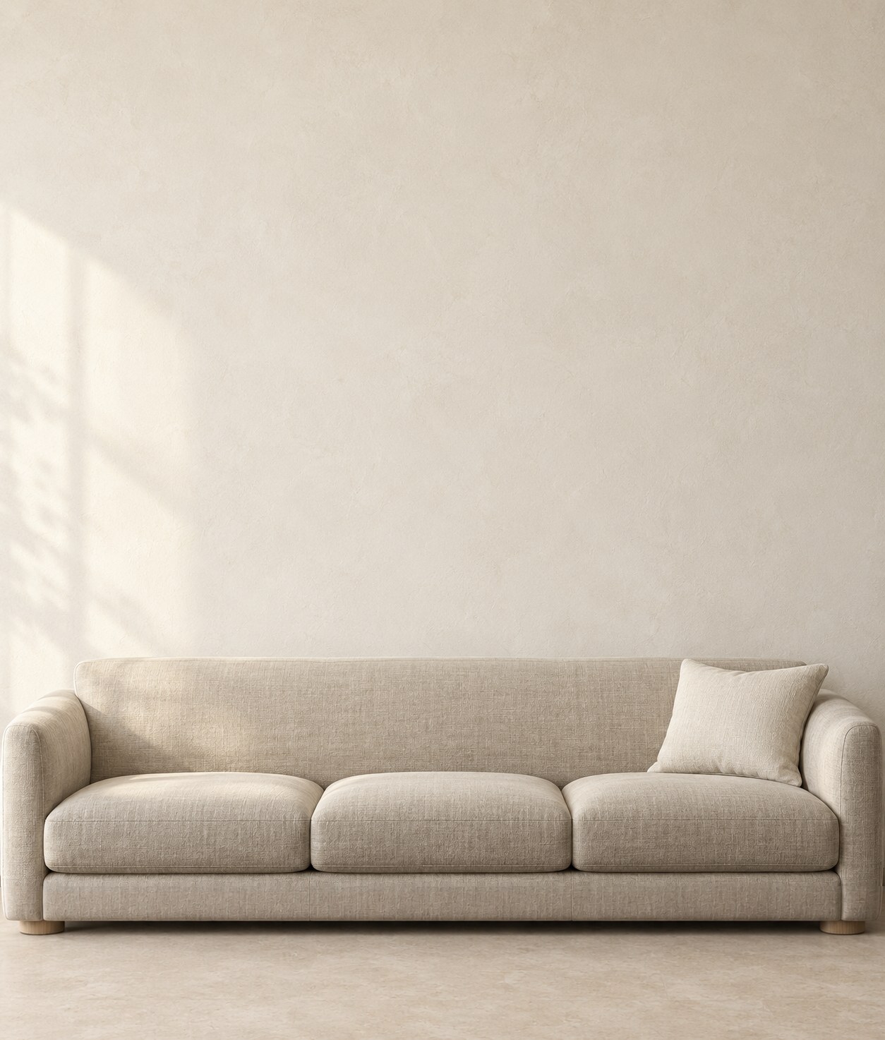 An ivory wall with an 87 in (220 cm) linen sofa